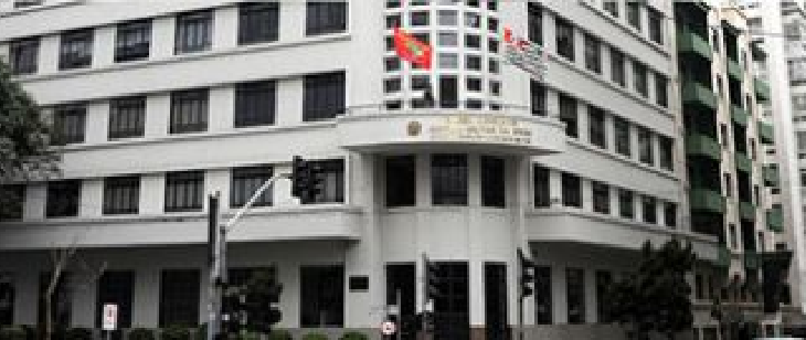 Fachada da 2ª Circunscrição Judiciária Militar, em São Paulo. Edifício de cor branca, com cinco andares e janelas alinhadas em fileiras horizontais. O prédio tem entrada em curva e bandeiras do Brasil e do estado de São Paulo hasteadas no topo. Ao redor, há semáforos, postes e outros prédios residenciais.